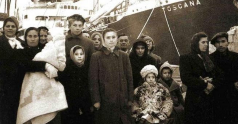 profughi ed esuli con alle spalle una nave