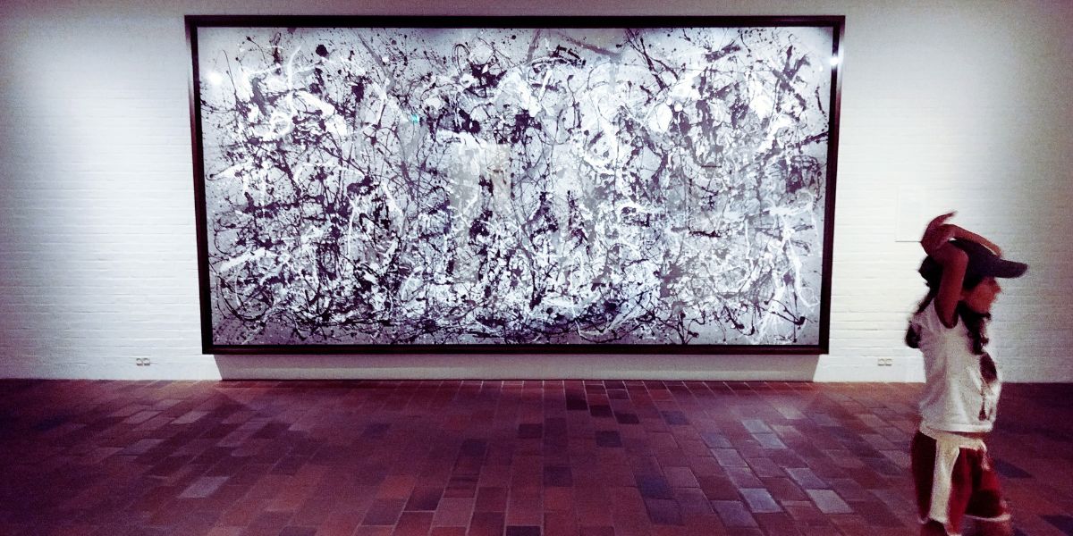 bambina e sullo sfondo un'opera d'arte