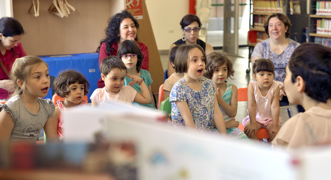  Bambine sedute in cerchio che ascoltano una storia