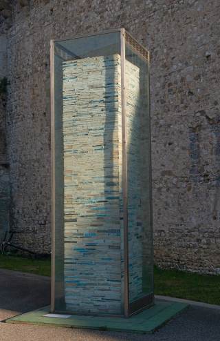 colonna con teca in vetro alta 4 metri contenente all\'interno colonne di libri murati in ordine verticale